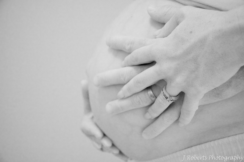 parents hands on Pregnant Belly - B&W pregnancy photography 